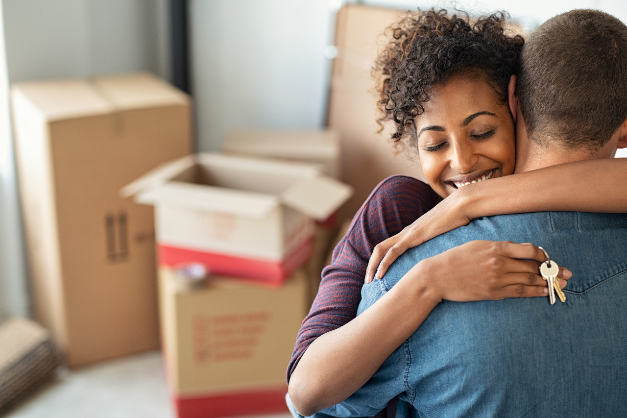 Couple holding new home keys and hugging