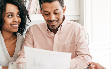 A group of people looking at a laptop.