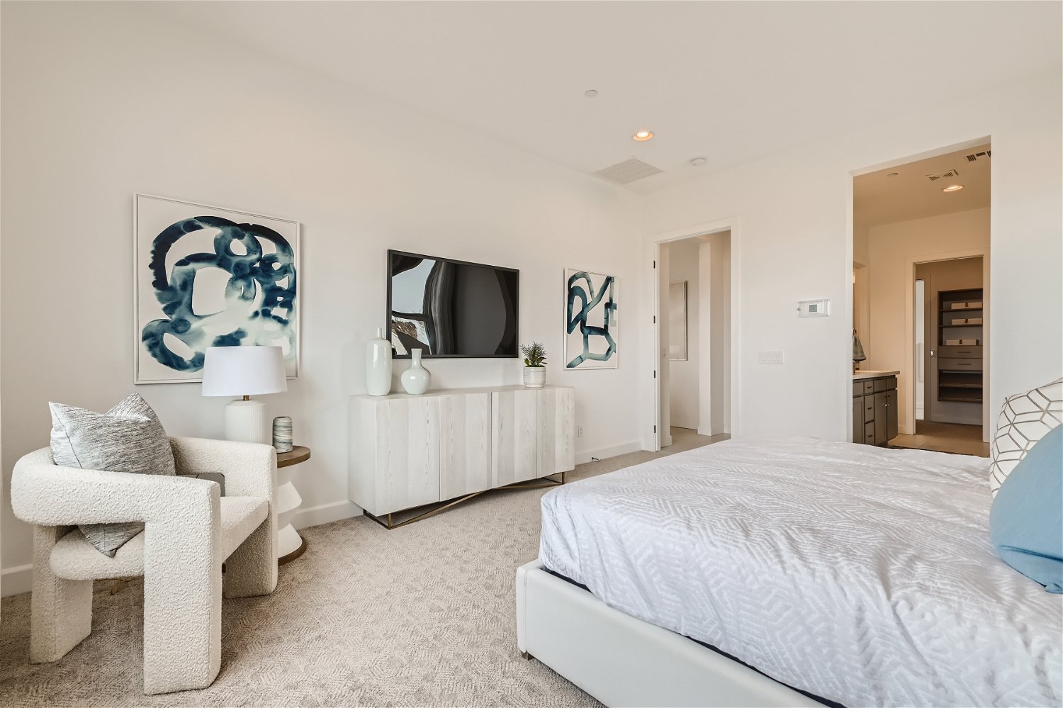 A bedroom with a bed and a chair.