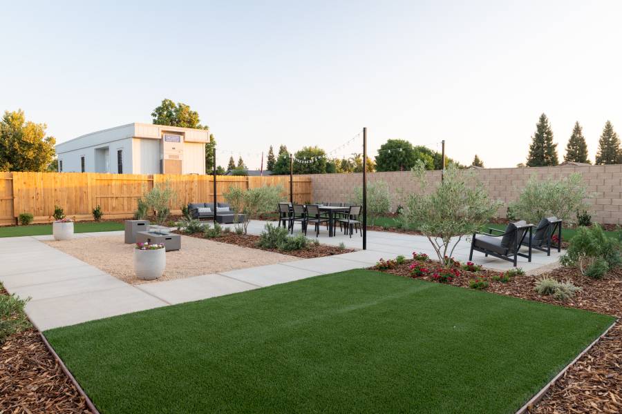 A backyard with a brick wall and a brick fence.