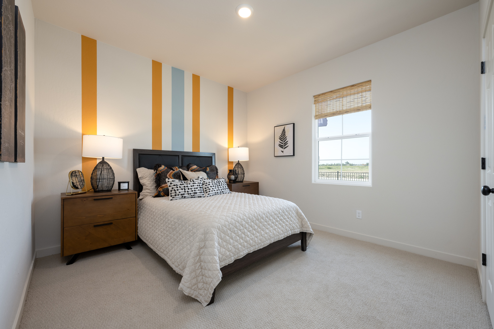 A bedroom with a bed and lamps.