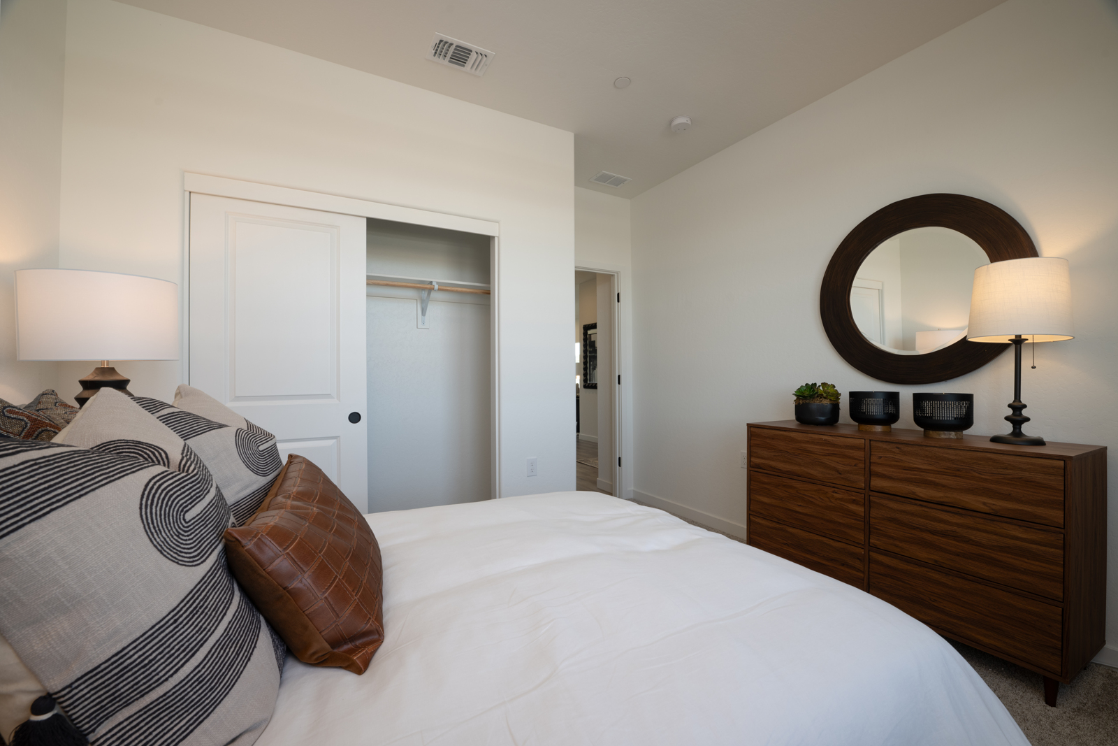 A bedroom with a bed and lamps.