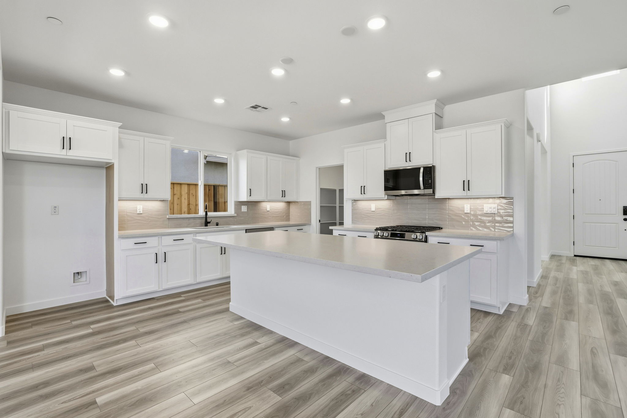 A kitchen with white cabinets.