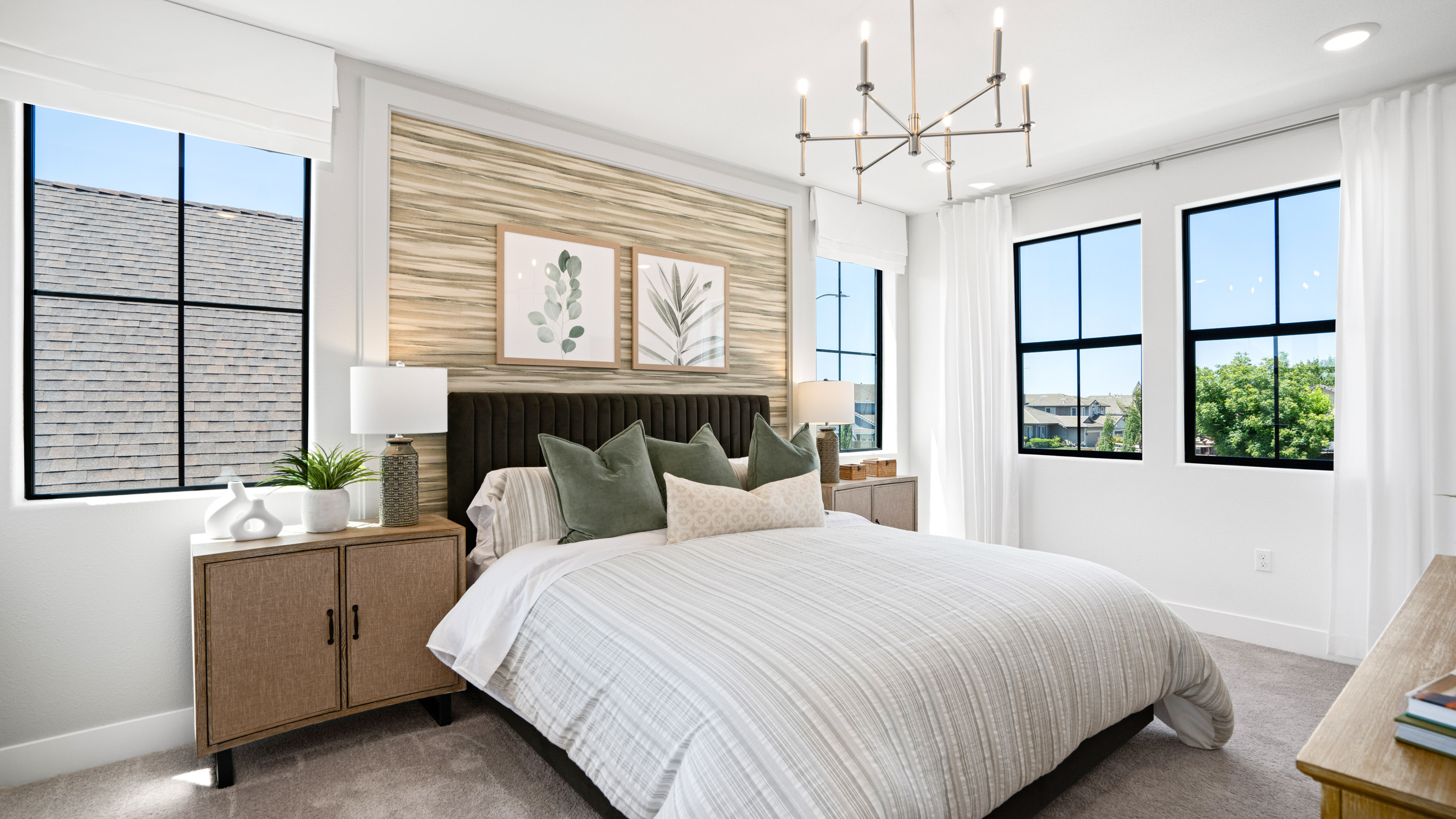 A bedroom with a bed and a chandelier.