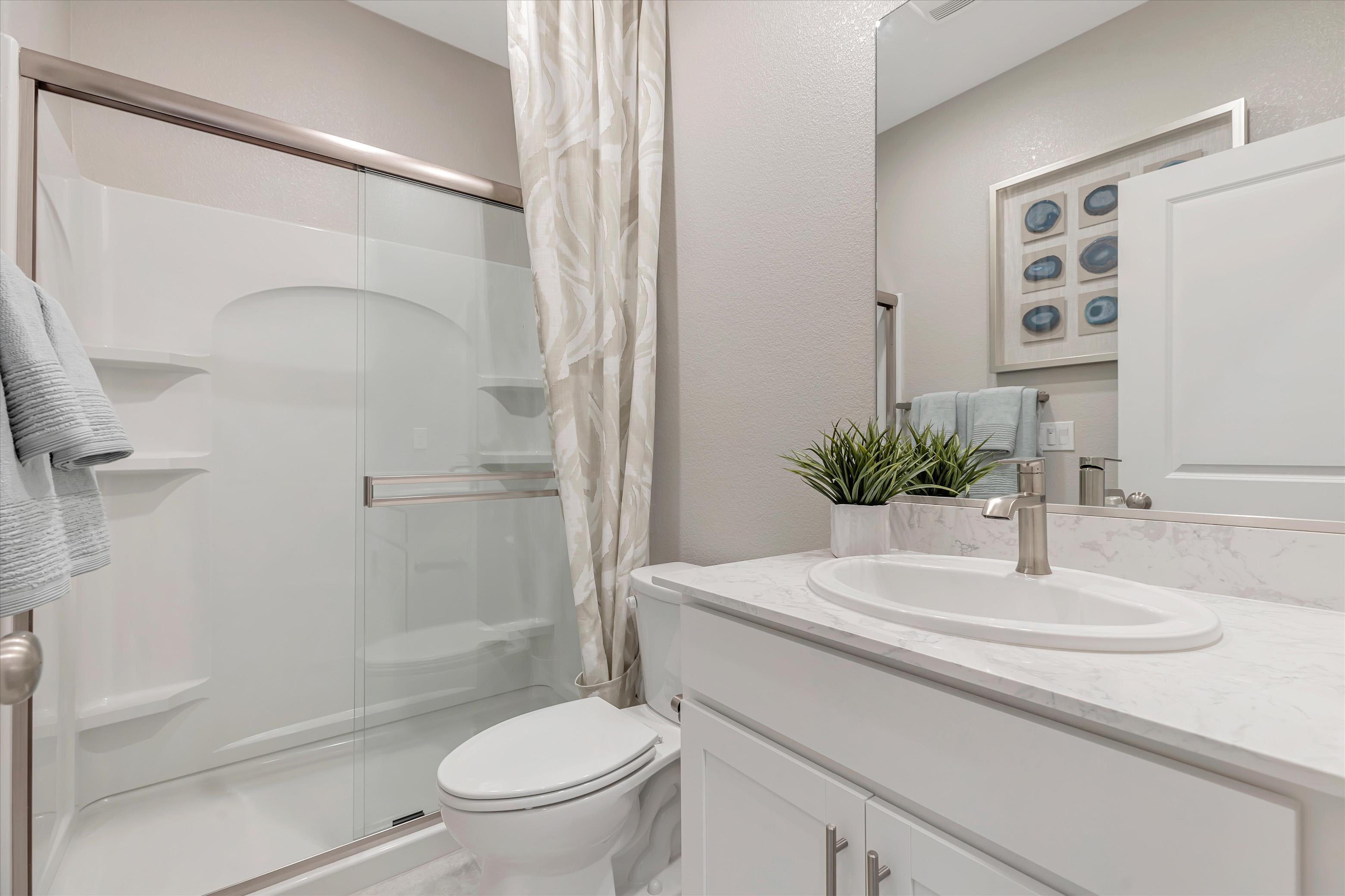 A bathroom with a sink toilet and shower.