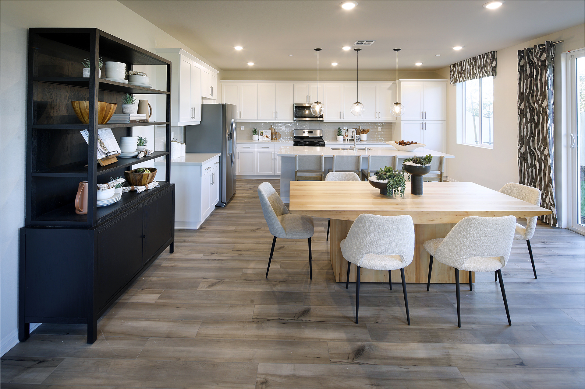 A kitchen with a dining table and chairs.