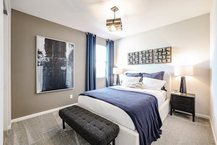 A bedroom with a bed and a bench.