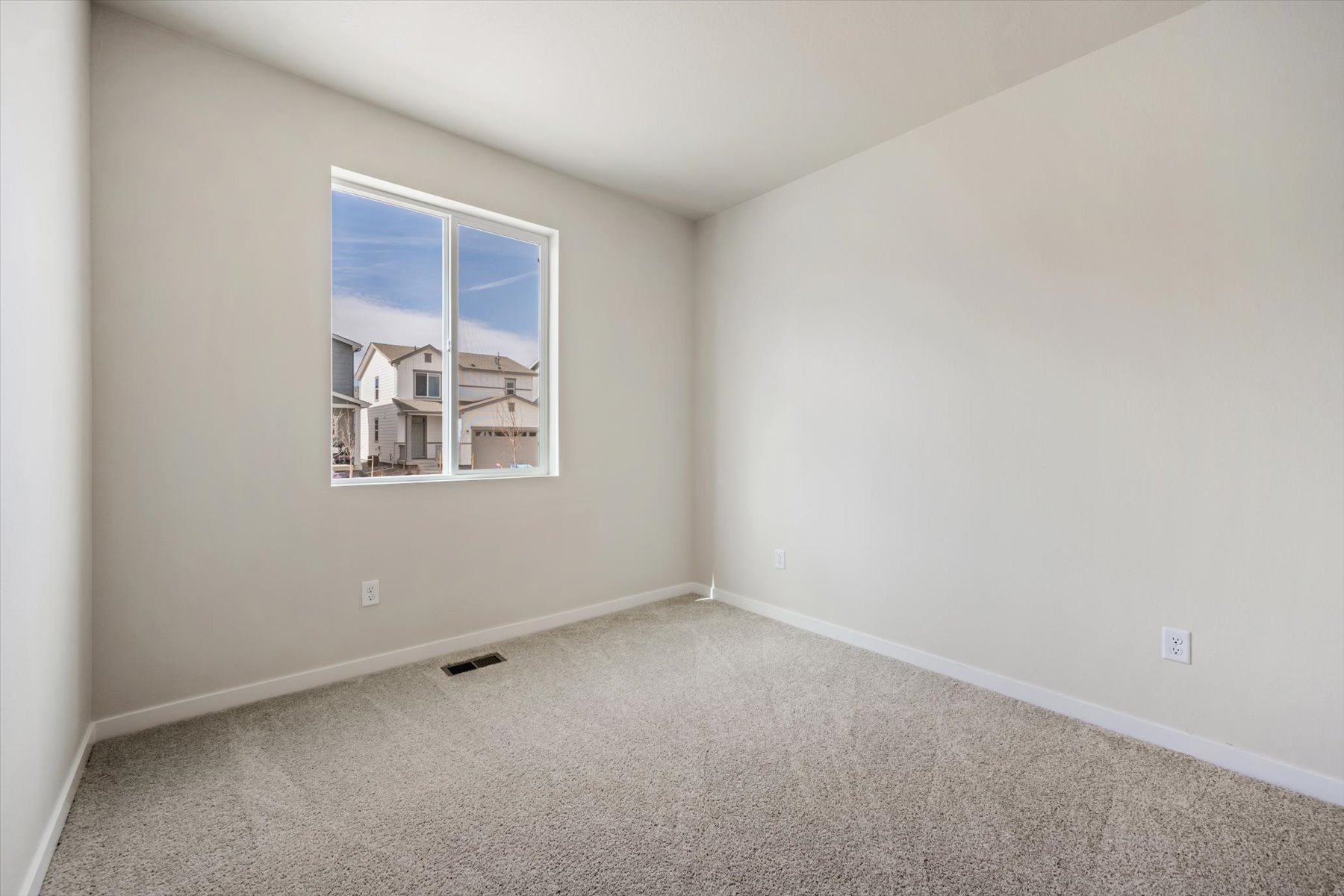 A room with a window and carpet.