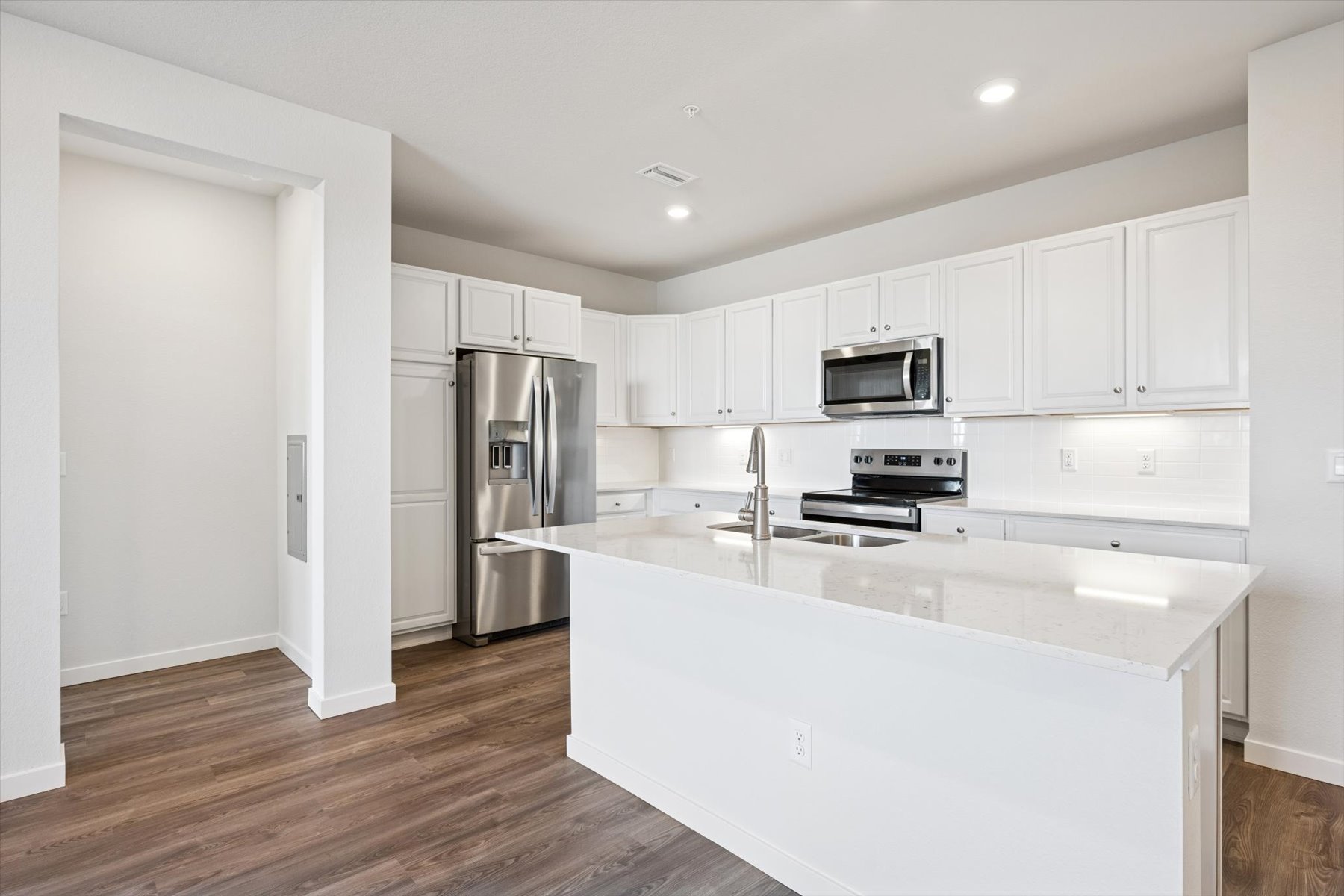 A kitchen with white cabinets.