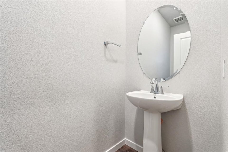 A bathroom with a round mirror.