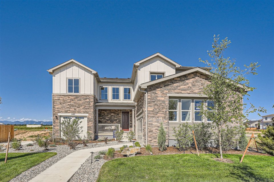 A house with a yard and a tree in front of it.
