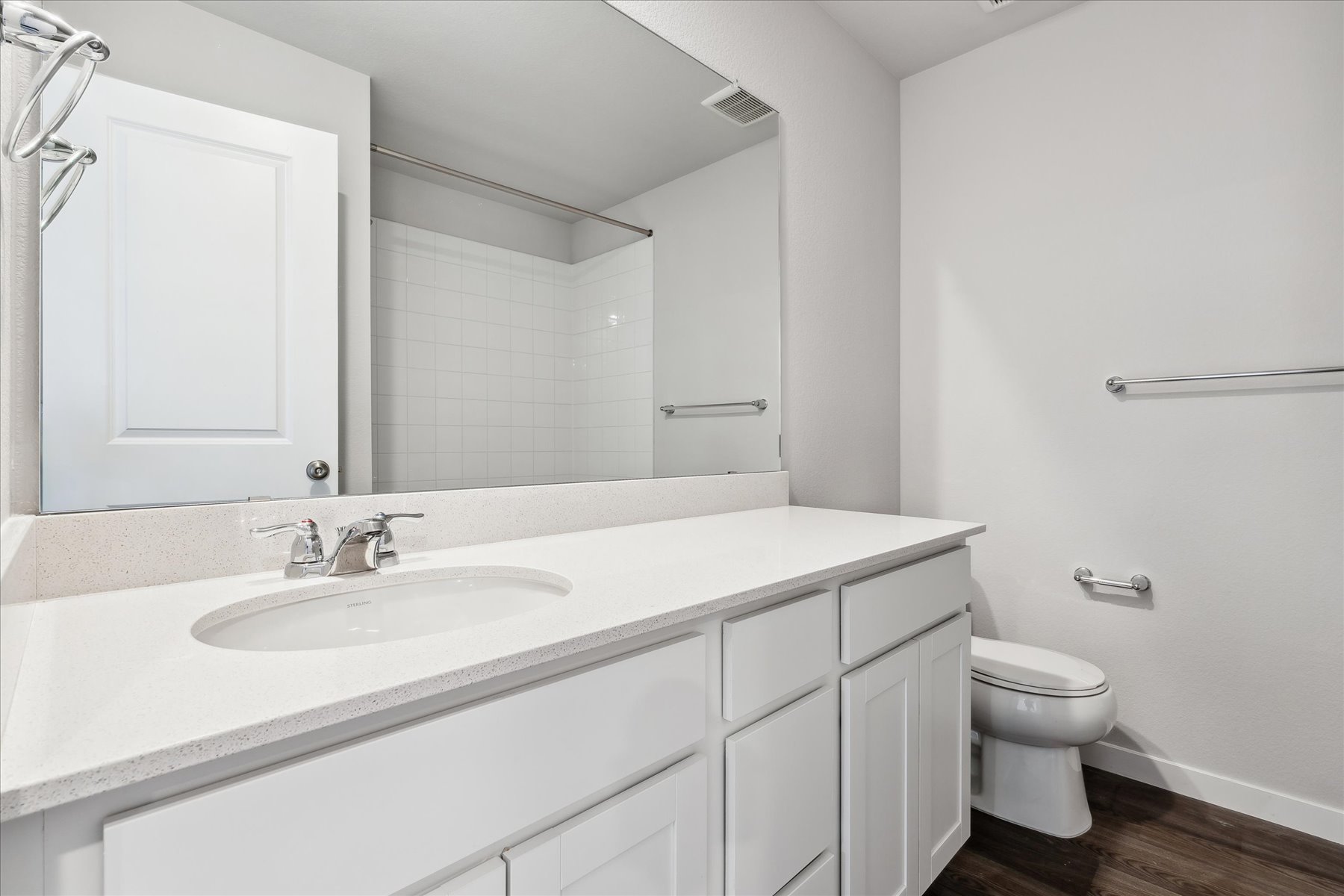 A bathroom with a large mirror.