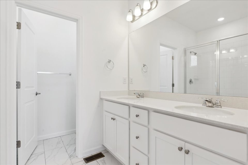 A bathroom with white cabinets.