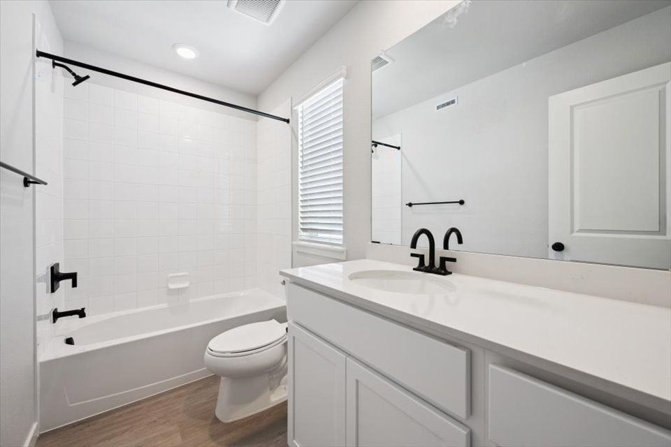 A bathroom with a tub toilet and sink.