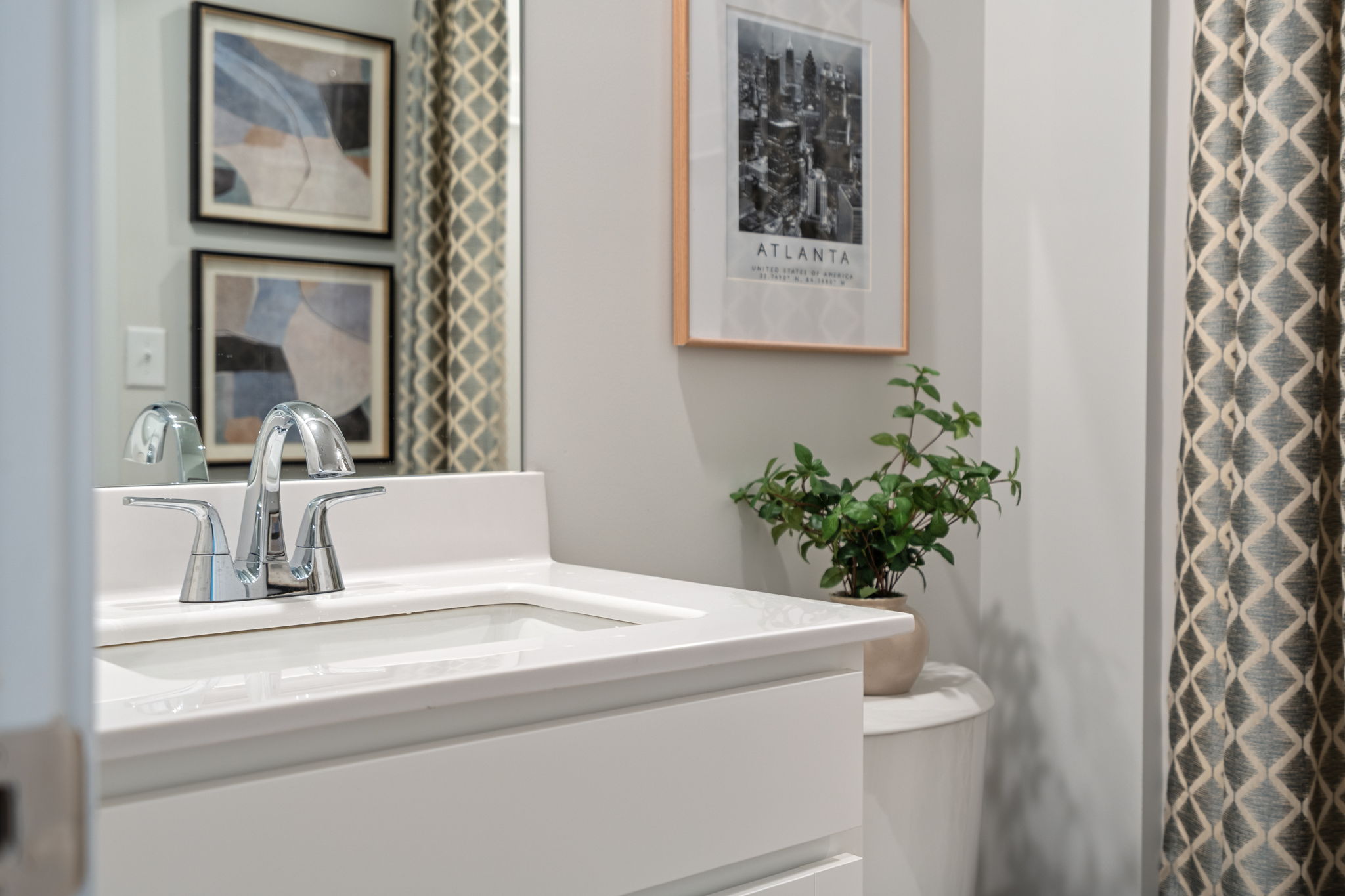 A bathroom with a sink and a plant.