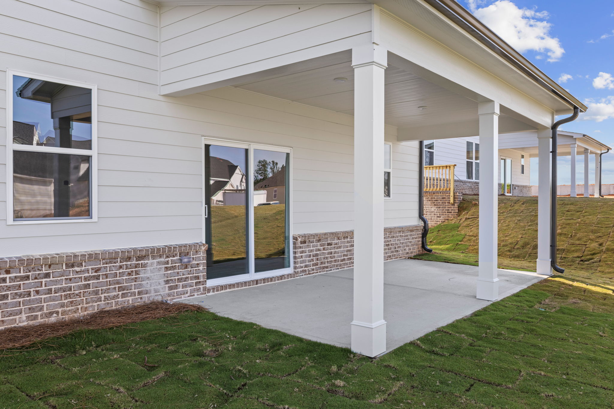 A house with a brick wall and a grass yard.