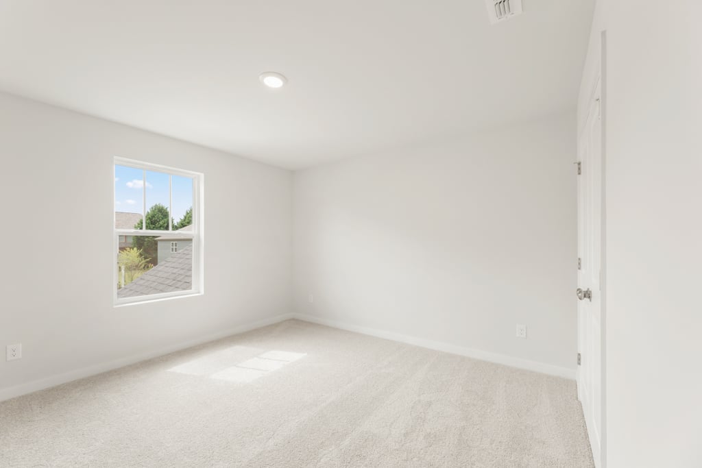 A room with a window and a carpet.