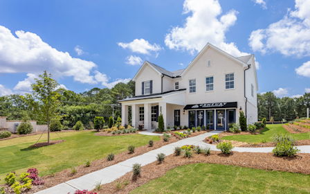 A large white house with a garden in front of it.