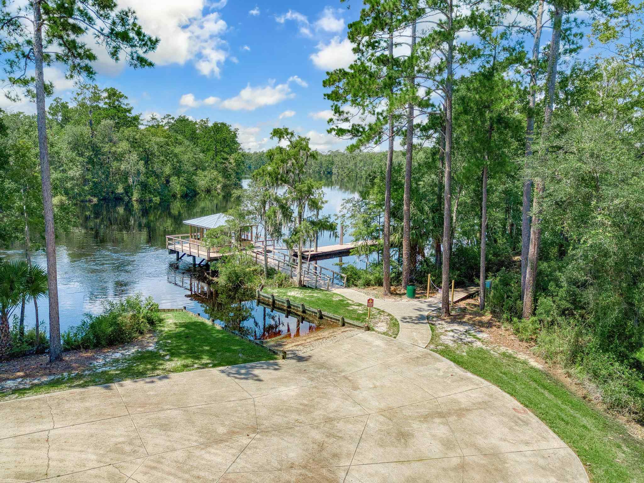 A path with trees and a body of water by it.