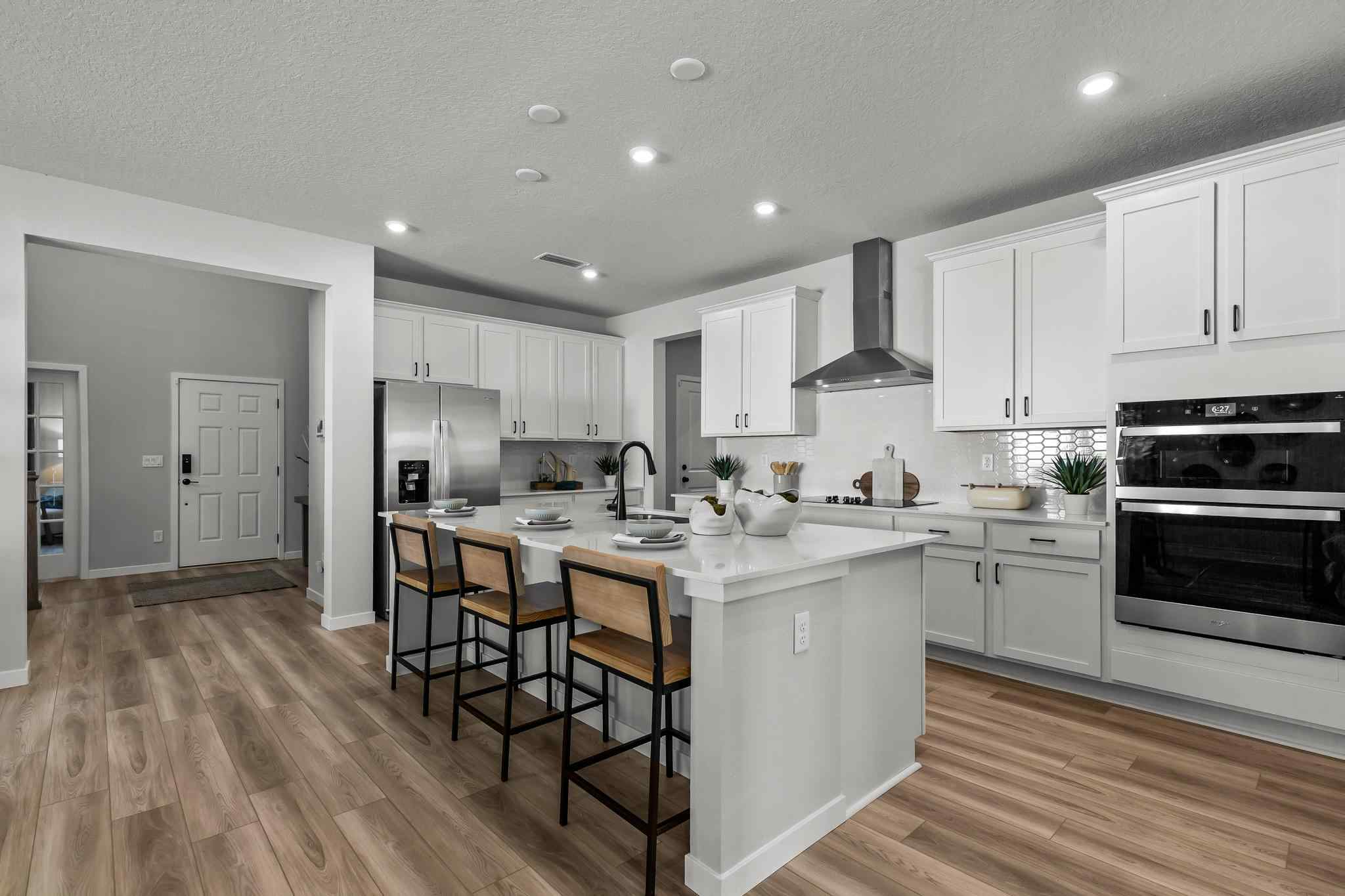 A kitchen with white cabinets.