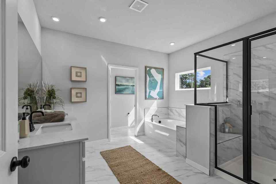 A bathroom with a tub sink and a shower.