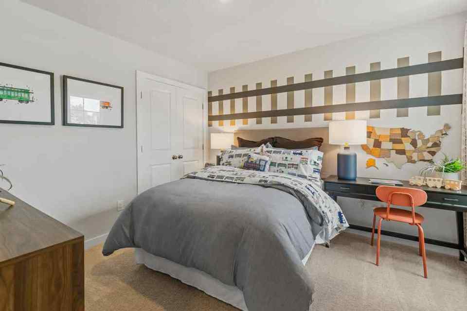 A bedroom with a bed and desk.