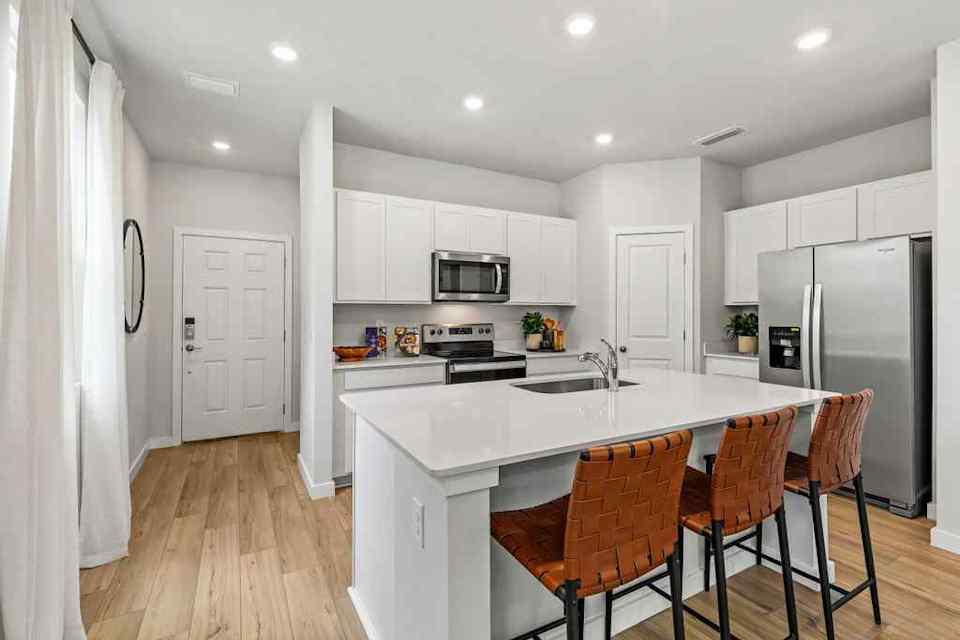 A kitchen with white cabinets.