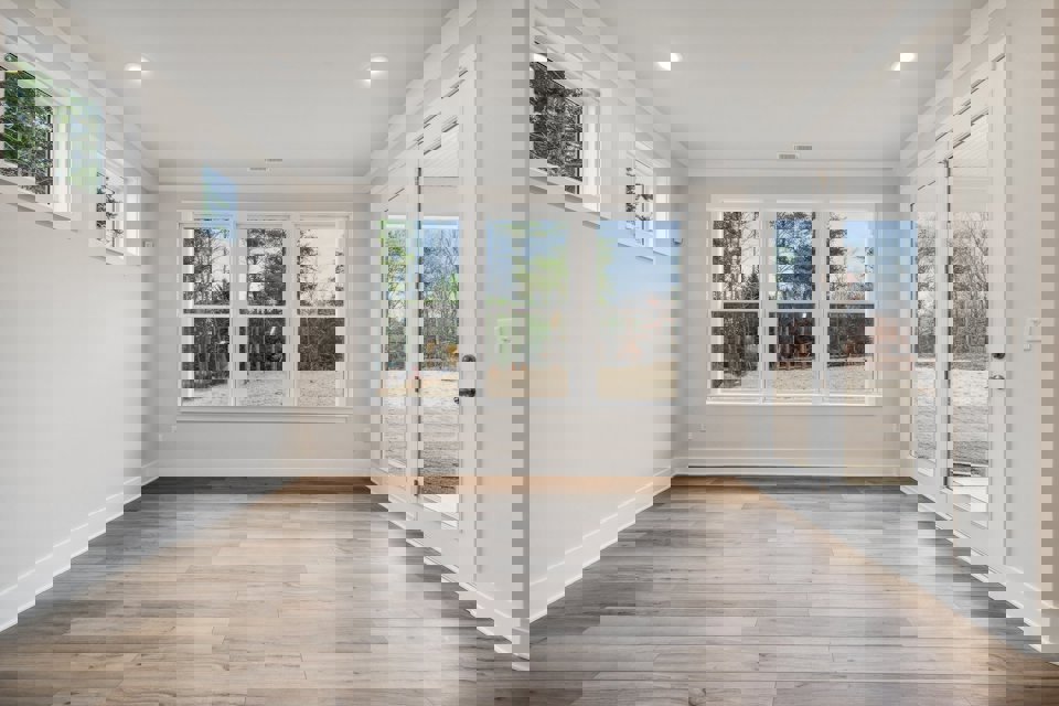 A room with a wood floor and windows.