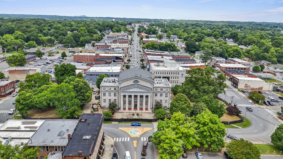 A large building with a dome and trees in front of it.