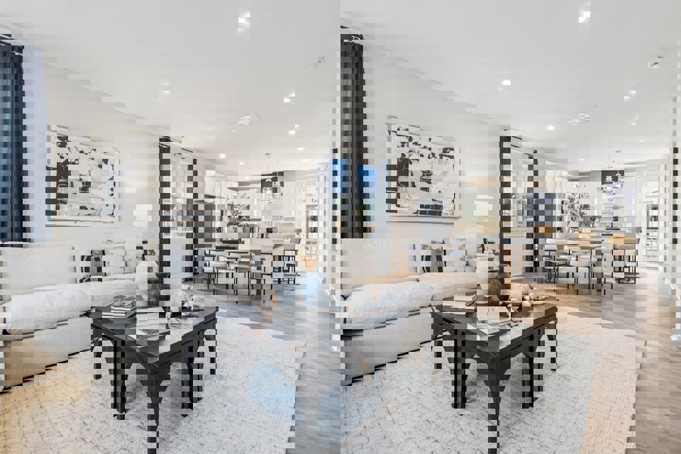 A large living room with a large dining table and a large painting.