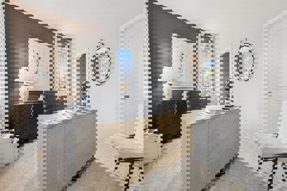 A room with a desk and chairs.