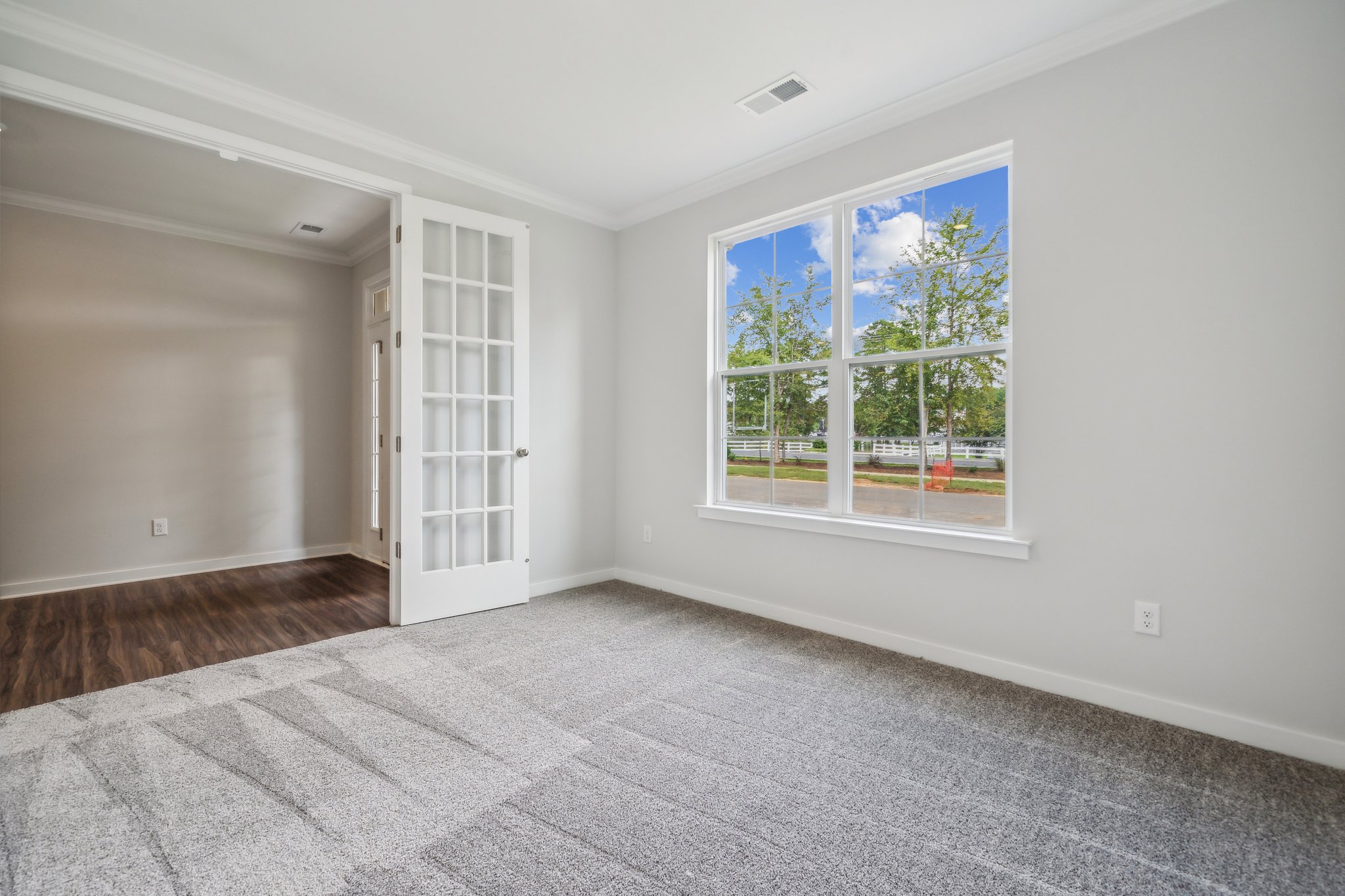 A room with a window and a rug.