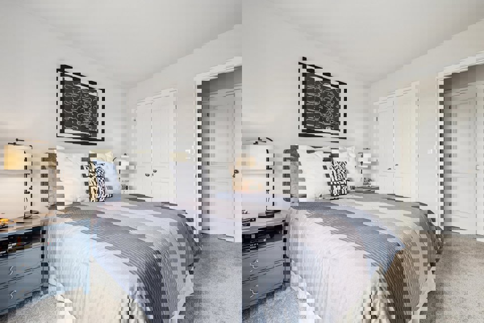 A bedroom with a bed and lamps.