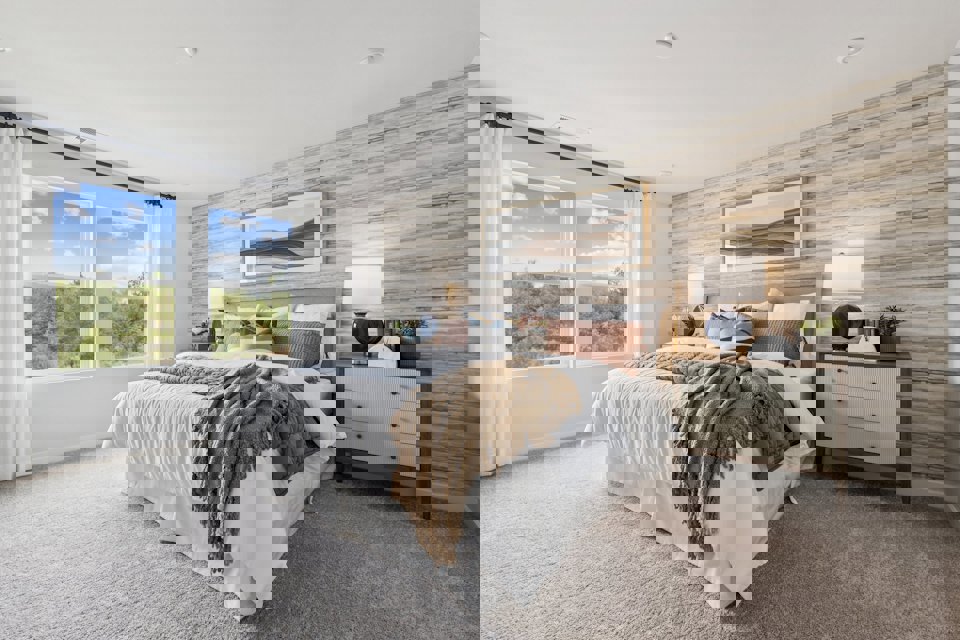 A bedroom with a bed and a window.