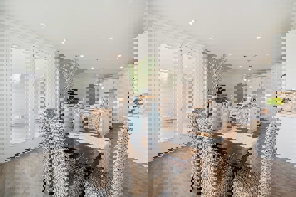 A kitchen with a dining table and chairs.