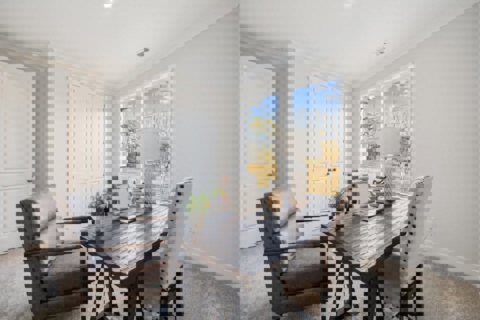 A living room with a table and chairs.