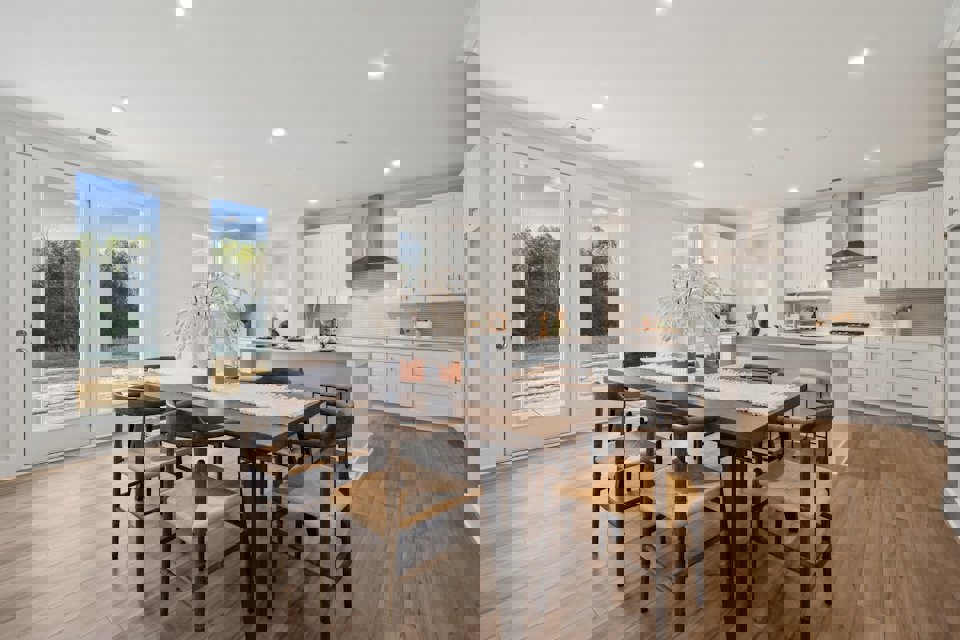 A kitchen with a dining table and chairs.