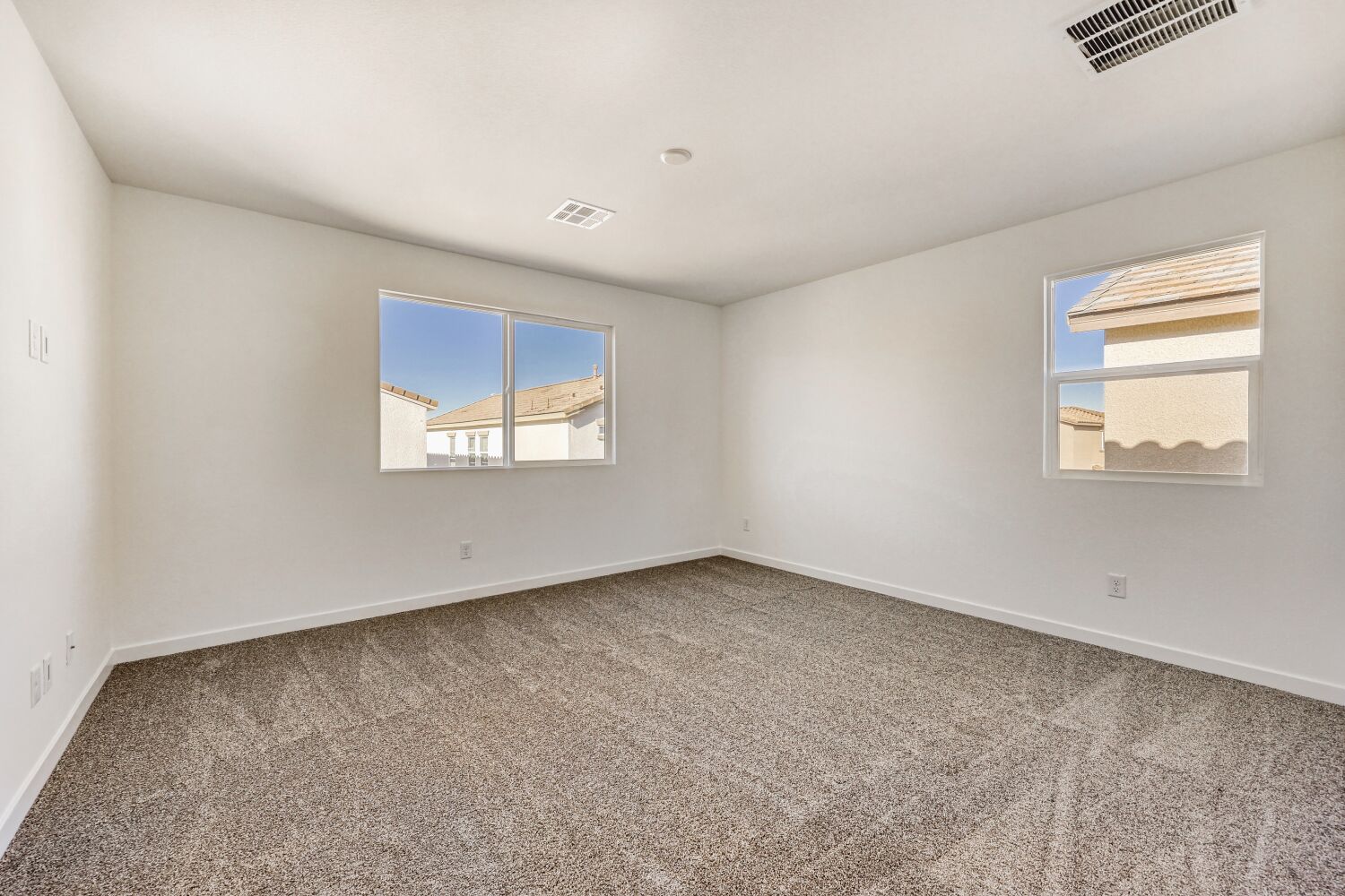 A room with a carpet and windows.