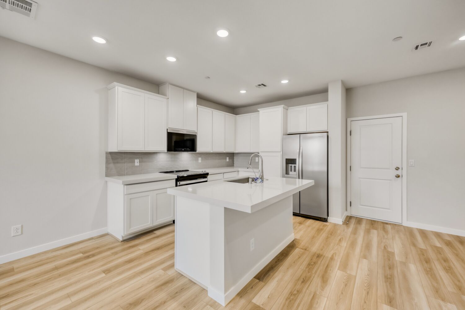 A kitchen with white cabinets.