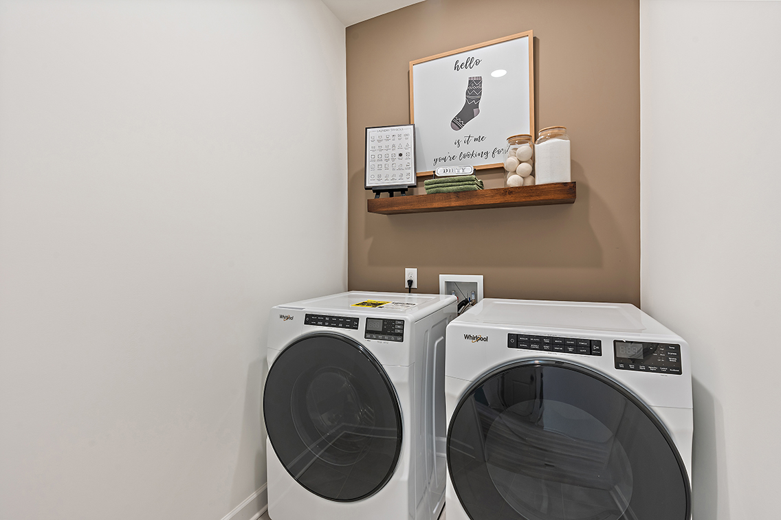 A white washing machine and a shelf.