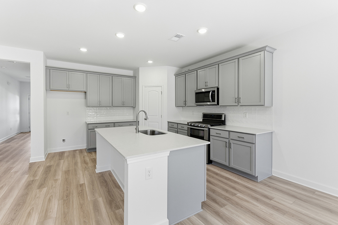 A kitchen with white cabinets.