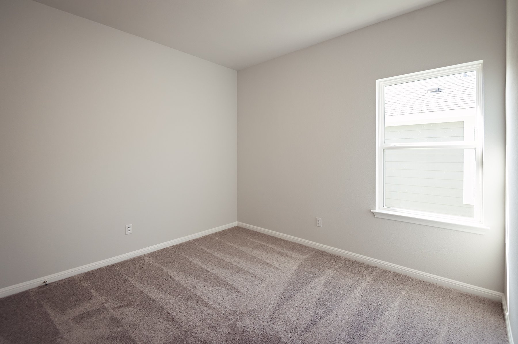 A room with a carpet and a window.