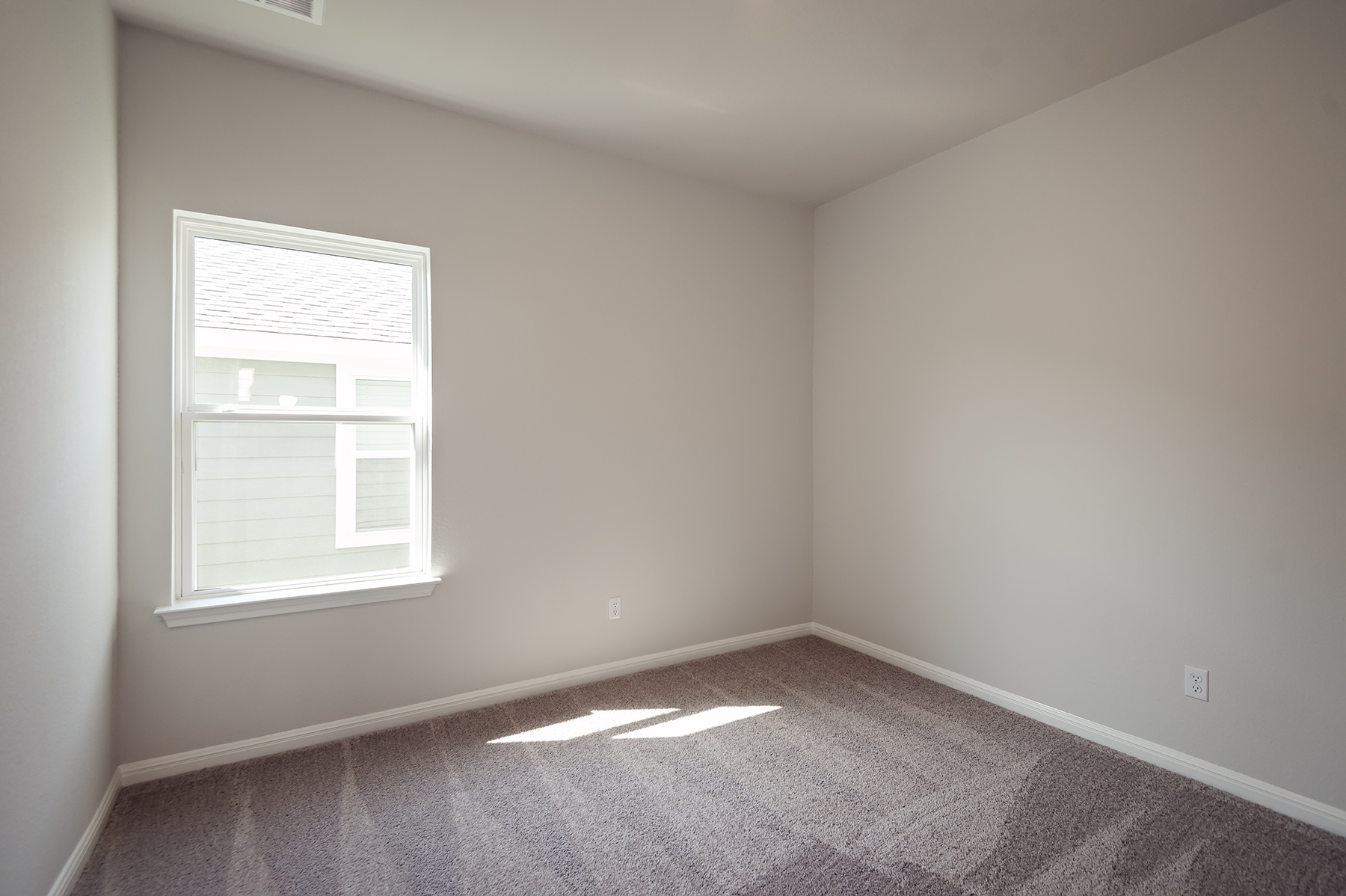 A room with a window and carpet.