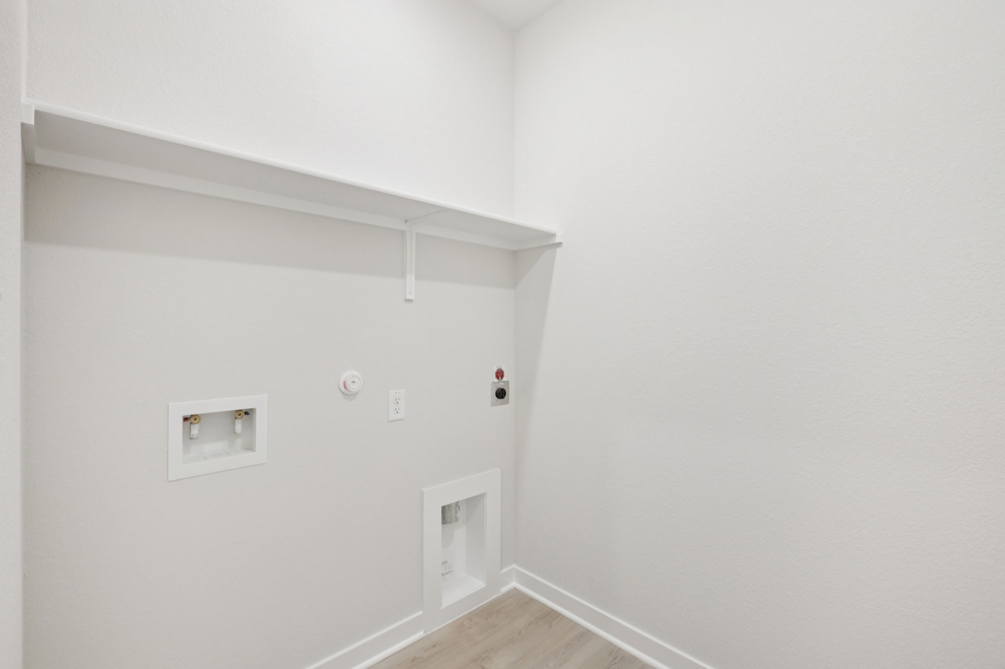 A white wall with a light switch.