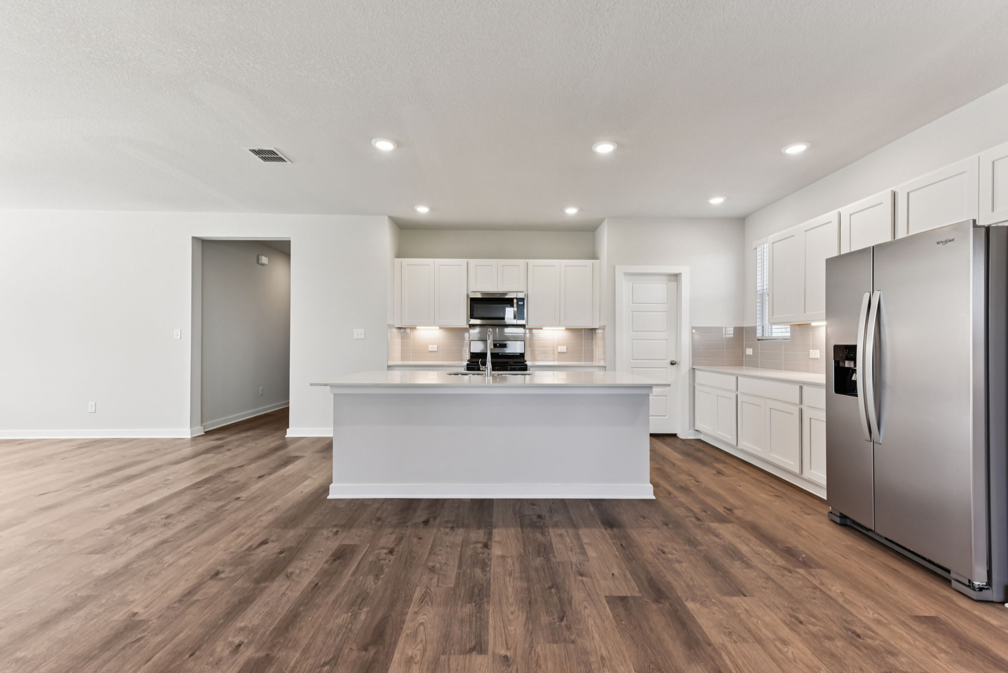 A kitchen with white cabinets.