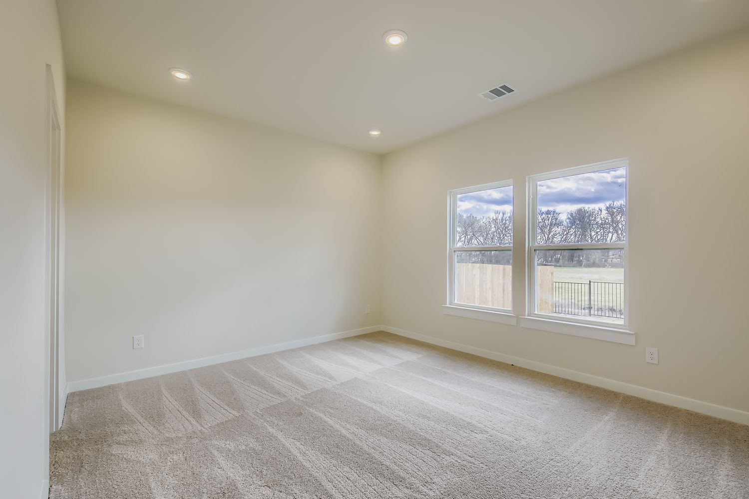 A room with a window and a carpet.