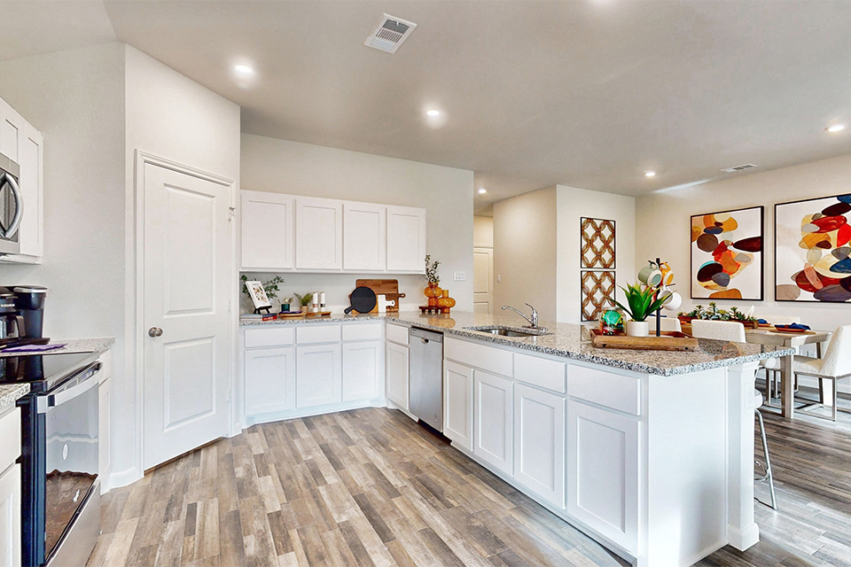 A kitchen with white cabinets.