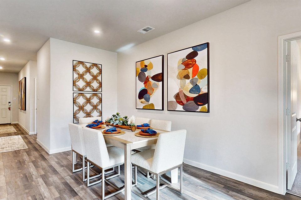 A dining room with a table and chairs.