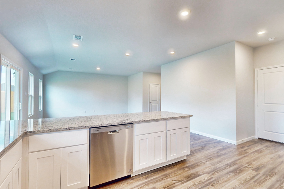 A kitchen with white cabinets.