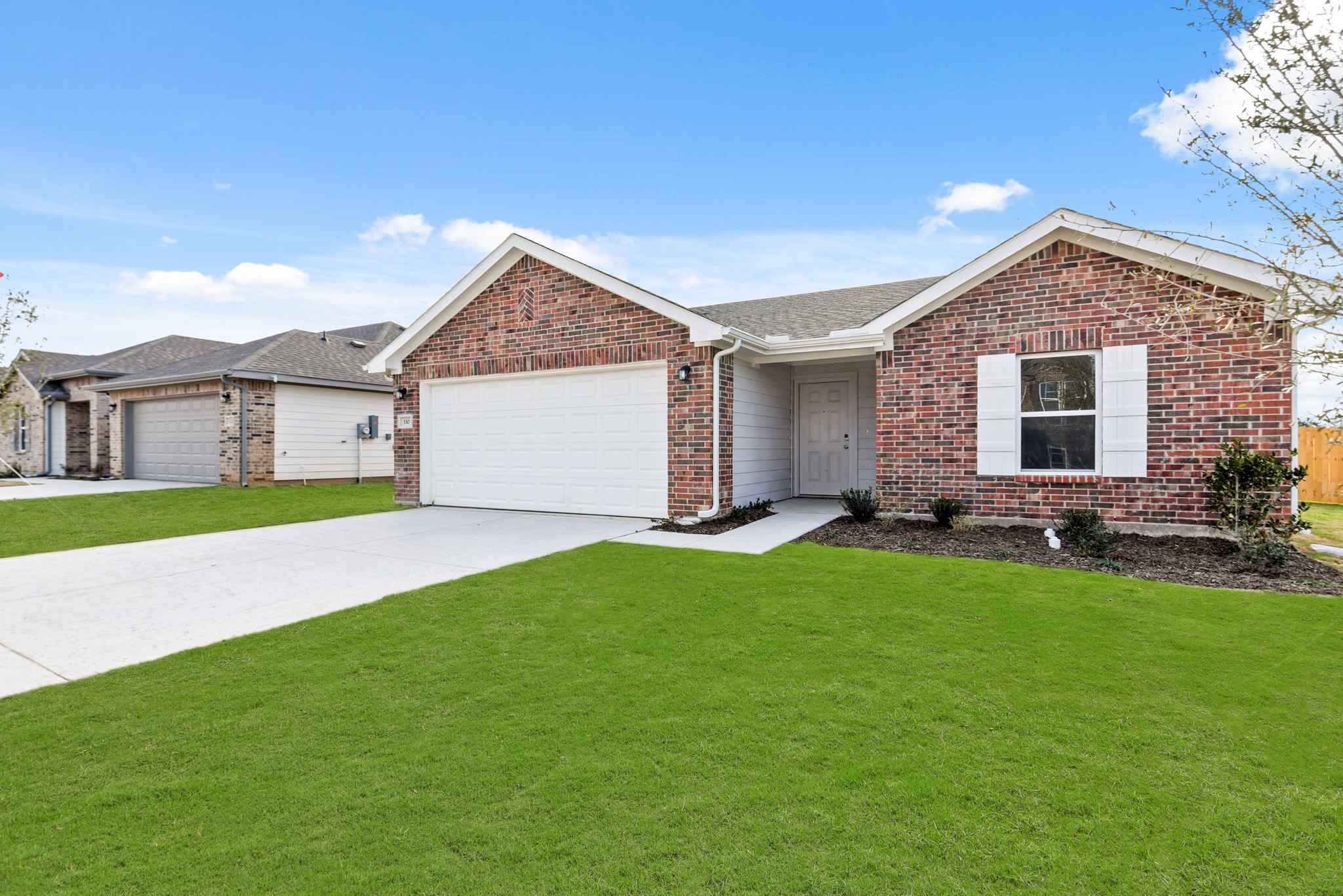 A brick house with garages.